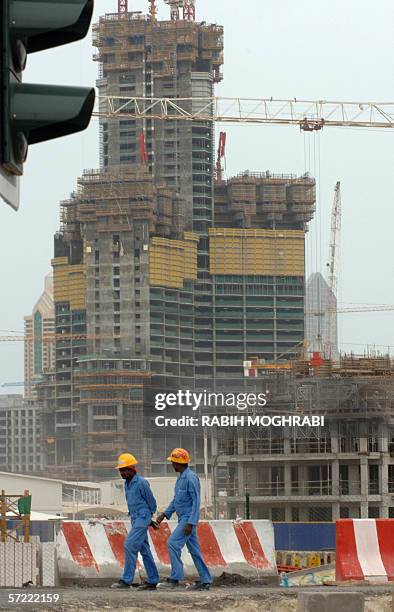 Dubai, UNITED ARAB EMIRATES: Asian workers are seen at a construction site in Dubai, 30 March 2006. The United Arab Emirates rejected today as...
