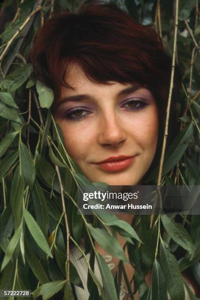 Successful female vocalist Kate Bush surrounded by leaves, in June 1978 in London, United Kingdom.