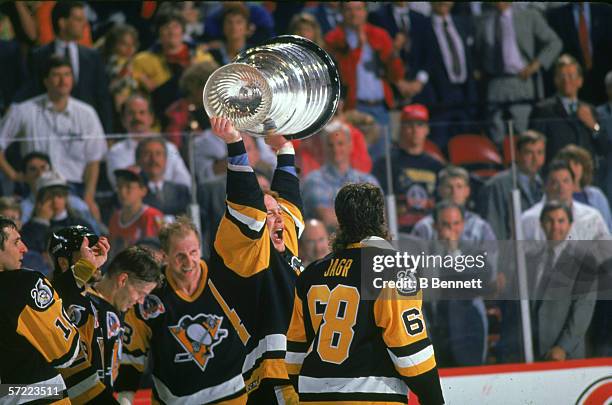 Canadian professional hockey player Troy Loney , forward for the Pittsburgh Penguins, hoists the Stanley Cup over his head and yells as he celebrates...