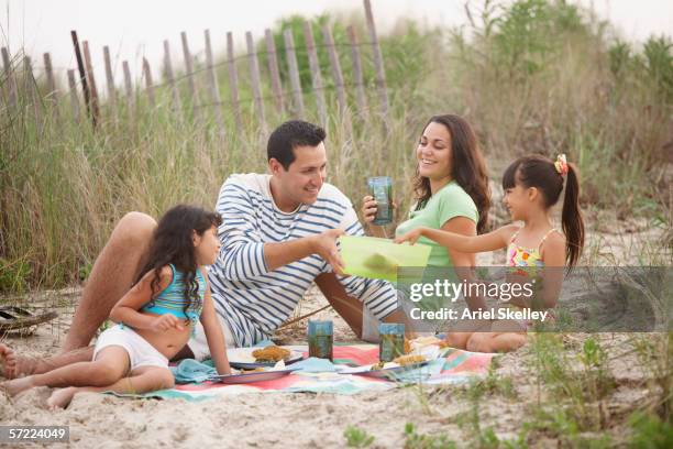 family picnicking on beach - shivering family stock pictures, royalty-free photos & images