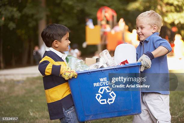 two boys carrying recycling container - mixed recycling bin stock pictures, royalty-free photos & images