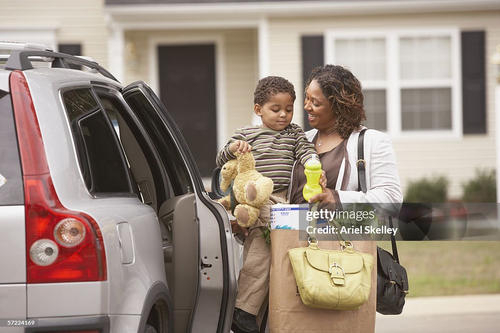Mother unloading son and groceries from van