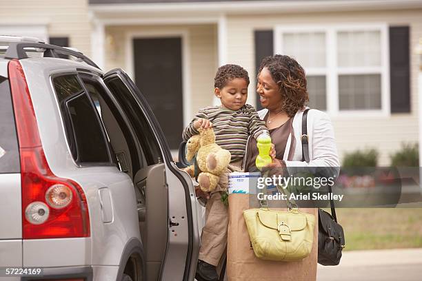 mother unloading son and groceries from van - busy toddlers stock pictures, royalty-free photos & images