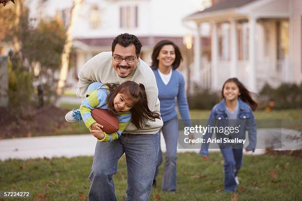 family playing football in front yard - american football family stock pictures, royalty-free photos & images