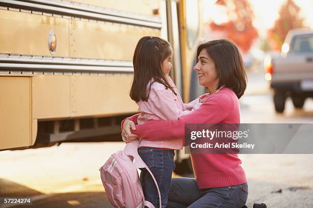 mother saying goodbye to daughter at school bus - leaving school imagens e fotografias de stock
