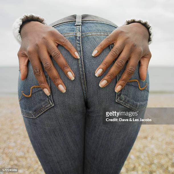 woman with her hands placed on buttocks - beach bum stock pictures, royalty-free photos & images