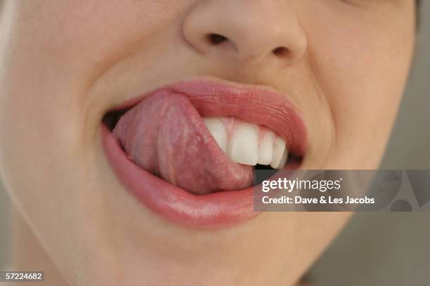 close up of young woman's tongue licking her lips - tongue stock pictures, royalty-free photos & images