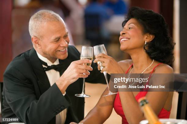 couple toasting each other over champagne - black tie dinner stock-fotos und bilder