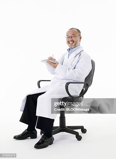 asian doctor smiling - arztstuhl stock-fotos und bilder