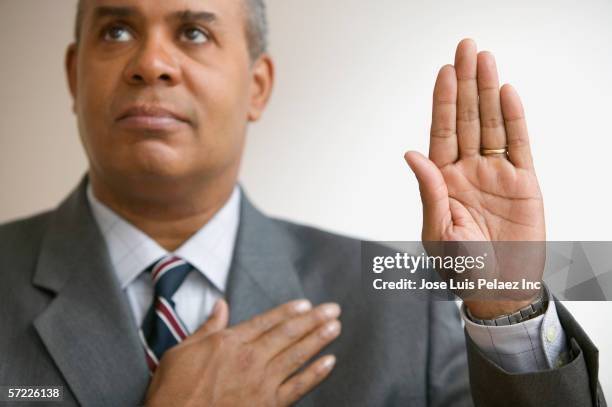 businessman pledging with hand raised - ed bildbanksfoton och bilder
