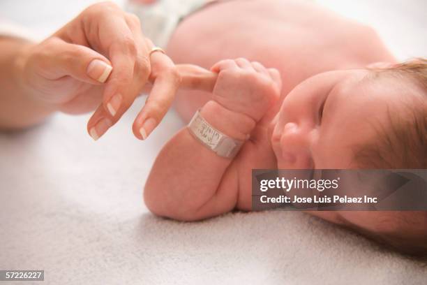 close up of baby holding mother's finger - identity stock pictures, royalty-free photos & images