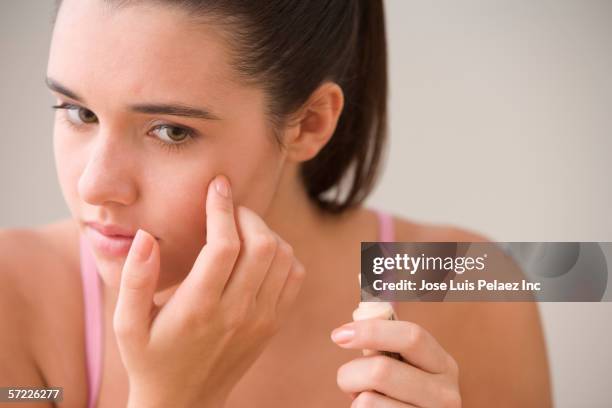 teenage girl applying cover up to face - beauty girl stock pictures, royalty-free photos & images