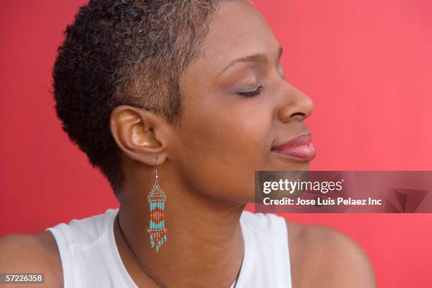 close up profile of mid adult woman with eyes closed - earring fotografías e imágenes de stock