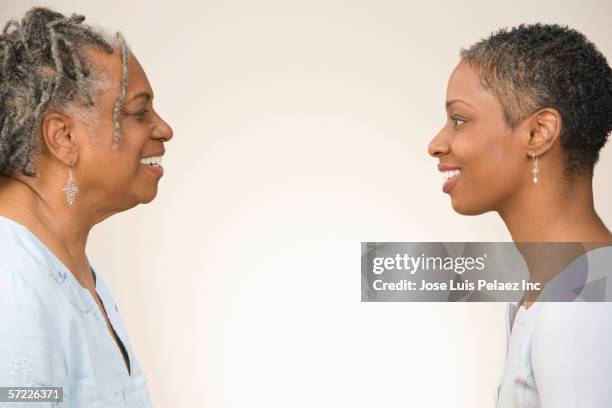 profile of mother and daughter facing each other - mother on white background stock pictures, royalty-free photos & images