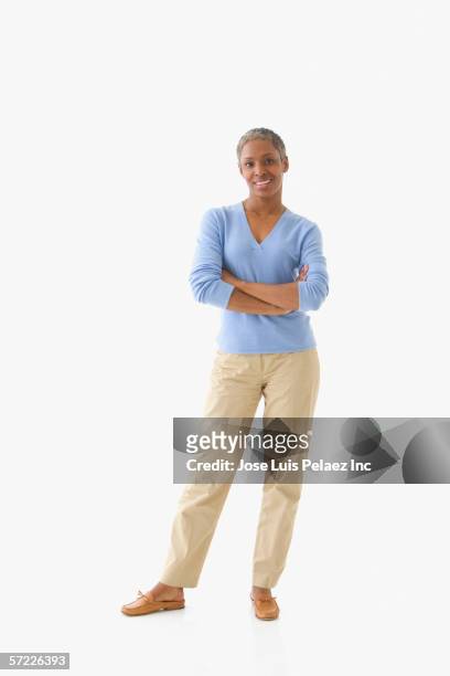 portrait of mid adult woman standing with arms crossed - front on portrait older full body foto e immagini stock