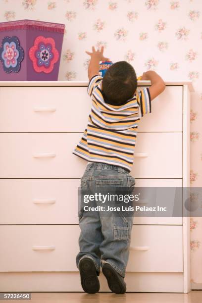 young boy reaching on dresser - child reaching stock pictures, royalty-free photos & images