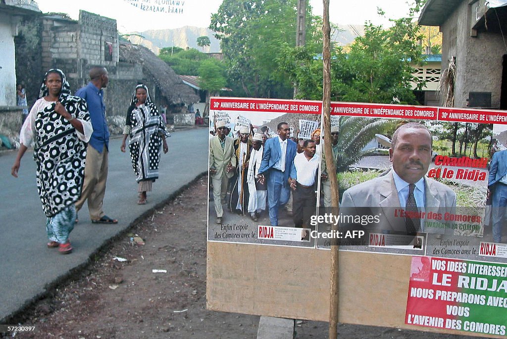 Residents of Anjouan walk past campaign