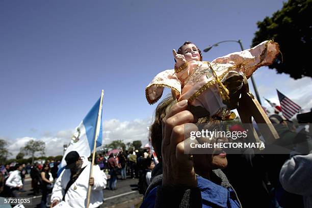 Costa Mesa, UNITED STATES: A woman walks the streets carrying a figure of baby Jesus during a demonstration against local authorities in Costa Mesa,...