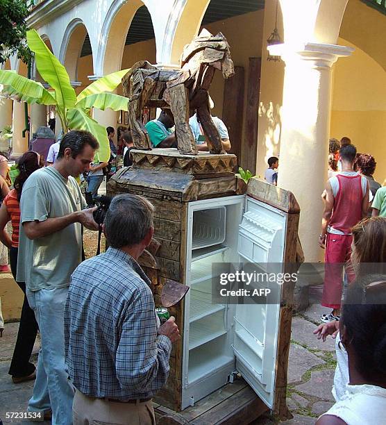Un grupo de personas observa un refrigerador de fabricacion estadounidense convertido en obra de arte, durante la Novena Bienal de La Habana, el 01...