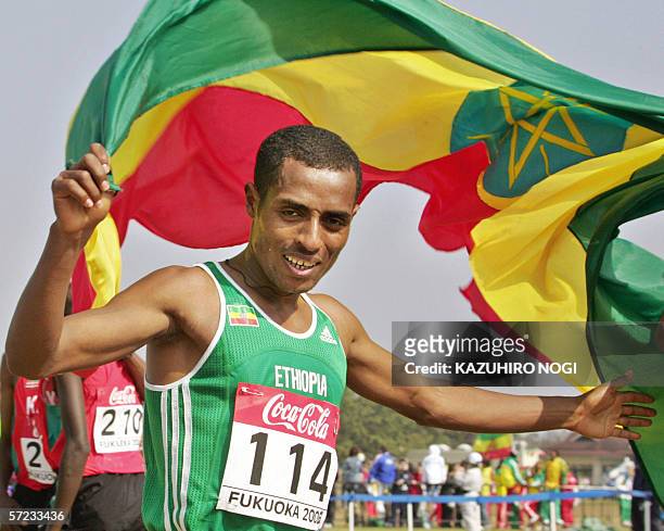 Ethiopia's Kenenisa Bekele holds his national flag as he celebrates his victory in the men's 12-kilometre race at the World Cross Country...