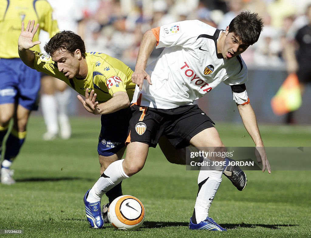 Valencia's David Villa (R) fights for th