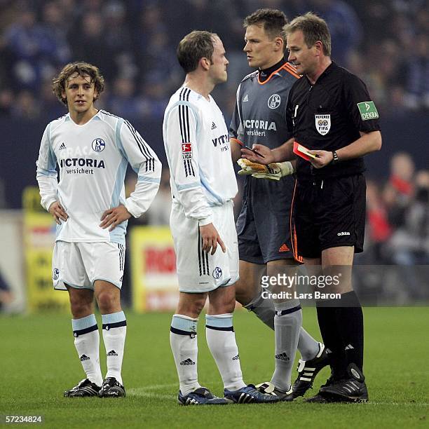 Fabian Ernst and goalkeeper Frank Rost of Schalke discus with Referee Helmut Fleischer, after he gaves Rafinha of Schalke the red card, during the...