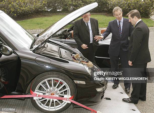 London, UNITED KINGDOM: British Prime Minister Tony Blair , Home Secretary Charles Clarke are shown cars and items confiscated by police as proceeds...