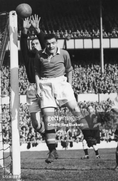 Manchester United goalkeeper, Wood, and right back, Bill Foulkes, make a concerted effort to clear a corner kick from Tottenham Hotspur during a...