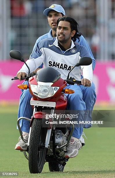 Indian cricketer Mahender Singh Dhoni and teammate Yuvraj Singh ride the man-of-the-match prize-a motorbike awarded to Yuvraj after the third one-day...