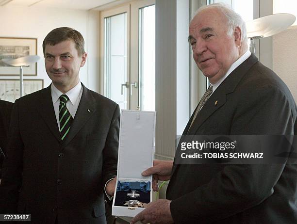 Estonian Prime Minister Andrus Ansip awards former German chancellor Helmut Kohl a Marienland medal during a ceremony in Berlin 03 April 2006. The...