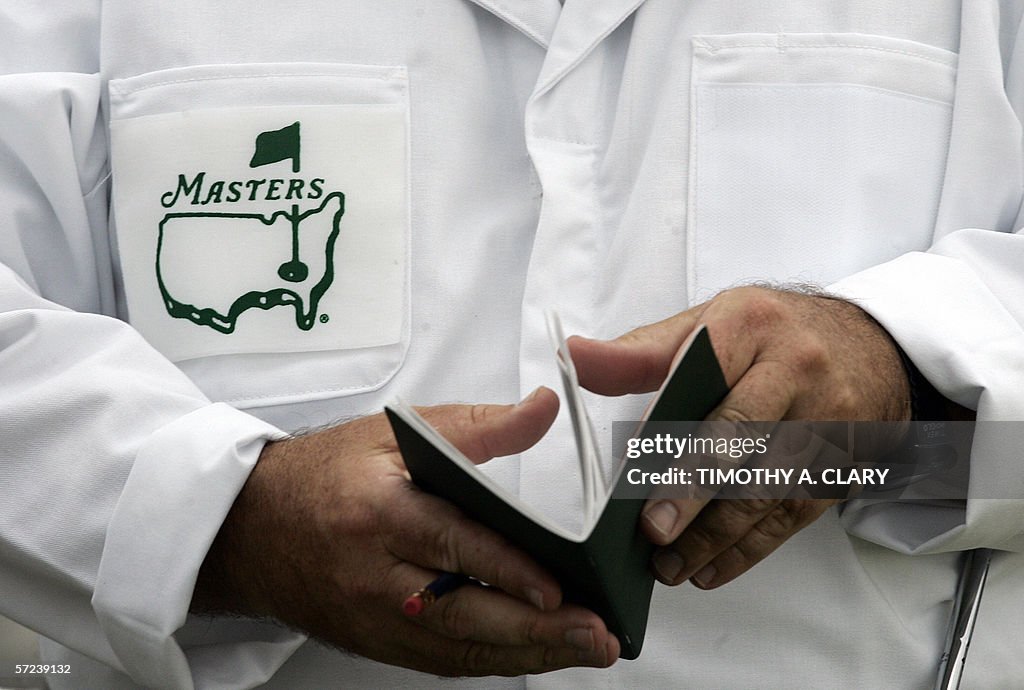 A caddie looks over his yardage book bef