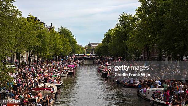 gay pride amsterdam: crowded street - moat stock pictures, royalty-free photos & images