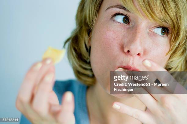 young woman holding bíscuit, licking finger - indulgence stockfoto's en -beelden