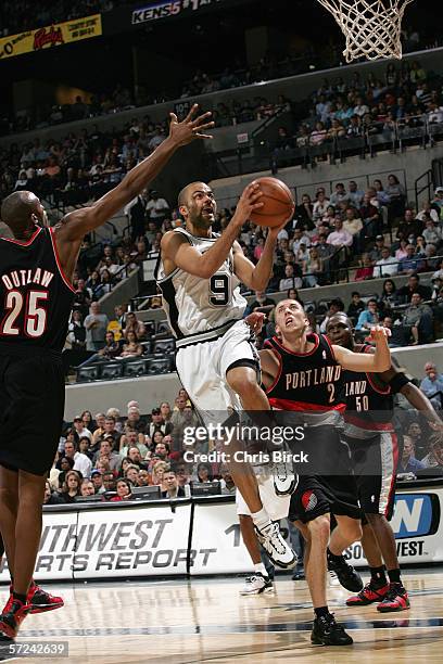 Tony Parker of the San Antonio Spurs takes the ball to the basket between Travis Outlaw and the Portland Trail Blazers at the AT&T Center on March 4,...