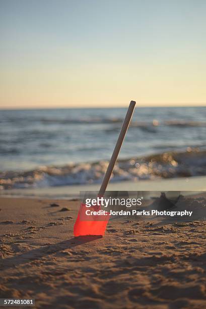 shovel in the sand - beach shovel stockfoto's en -beelden