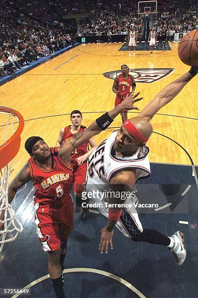 Vince Carter of the New Jersey Nets dunks against Josh Smith of the Atlanta Hawks on April 4, 2006 at the Continental Airlines Arena in East...