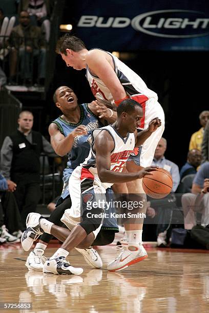 Brevin Knight of the Charlotte Bobcats cuts to the inside while Primoz Brezec of the Charlotte Bobcats blocks Rashad McCants of the MInnesota...