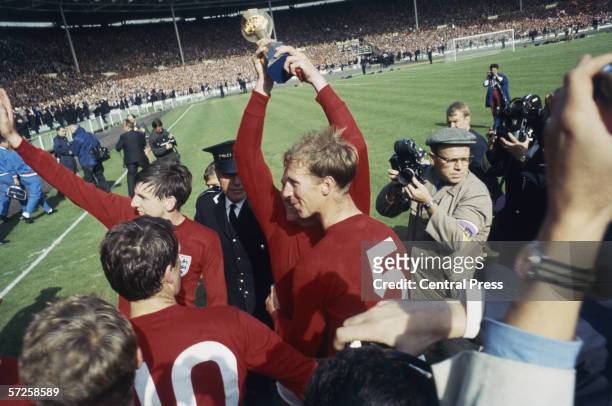 Martin Peters and Jack Charlton celebrate on the pitch after England's victory in the 1966 World Cup final at Wembley, 30th July 1966. Captain Bobby...