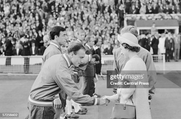 Queen Elizabeth II shaking hands with footballer George Cohen at Wembley before England's first group game of the 1966 World Cup, 11th July 1966....