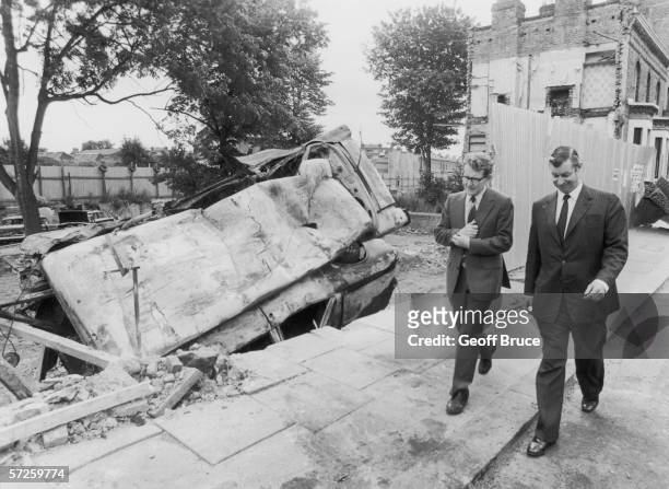 Home Office official Robert Morris and Malcolm Ferguson, in charge of community relations at Scotland Yard, touring the scene of rioting in Brixton,...