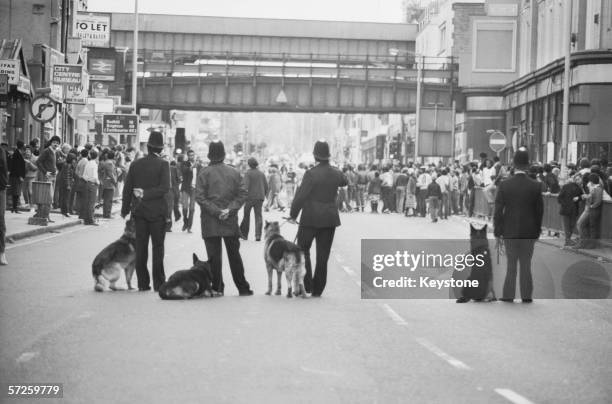 Police dog handlers on Atlantic Road on the second day of riots in Brixton, South London, 13th April 1981.
