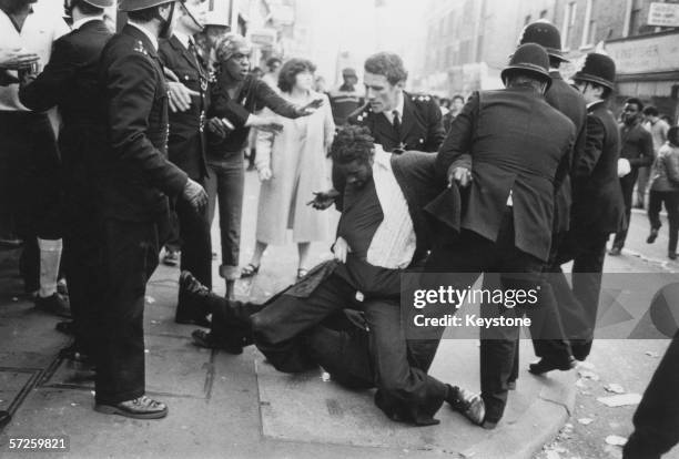 Police officers make an arrest on the second day of riots in Brixton, London, 13th April 1981.
