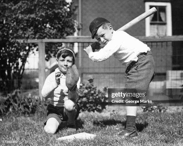 two boys (6-7) playing baseball in garden, (b&w) - 1930s stock pictures, royalty-free photos & images