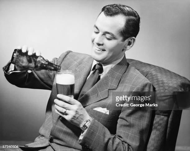 eleganten mann gießen flasche bier in glas (b & w - 1950s style stock-fotos und bilder