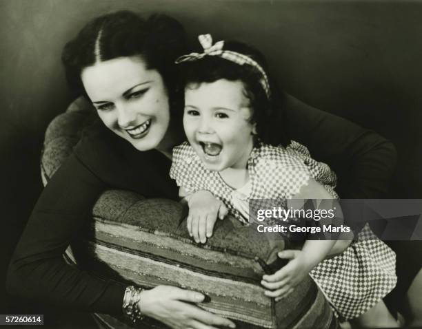 mother on couch with daughter (4-5), (b&w) - kinder 40er jahre stock-fotos und bilder