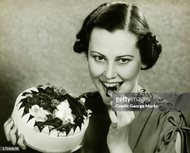 young woman a chocolate from box, posing, (b&w), portrait - 30s woman eating stock pictures, royalty-free photos & images