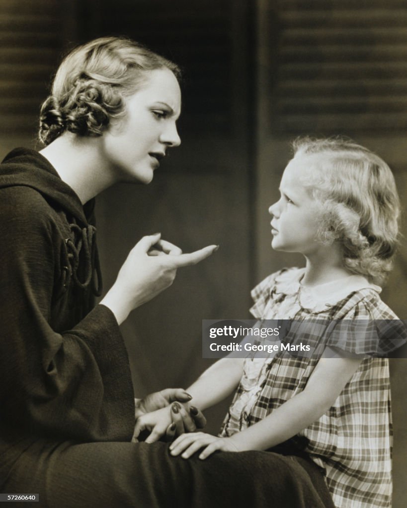 Mother scolding daughter (6-7), (B&W)