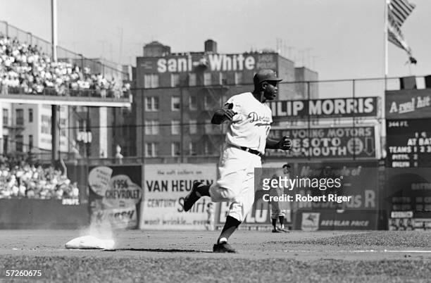 American baseball player Jackie Robinson of the Brooklyn Dodgers rounds third base during a home game at Ebbets Field, New York, New York, 1950s.