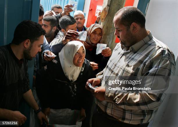 Palestinians reach out for World Food Program food handouts of cooking oil, macaroni and halal meet during distribution April 5, 2006 in Gaza City,...