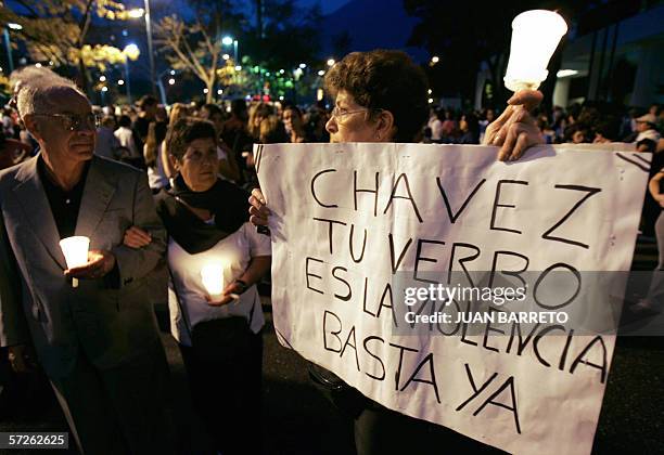 Manifestantes portan un cartel contra el presidente de Venezuela Hugo Chavez duranate una protesta en Caracas el 05 de abril de 2006. Un fotografo de...